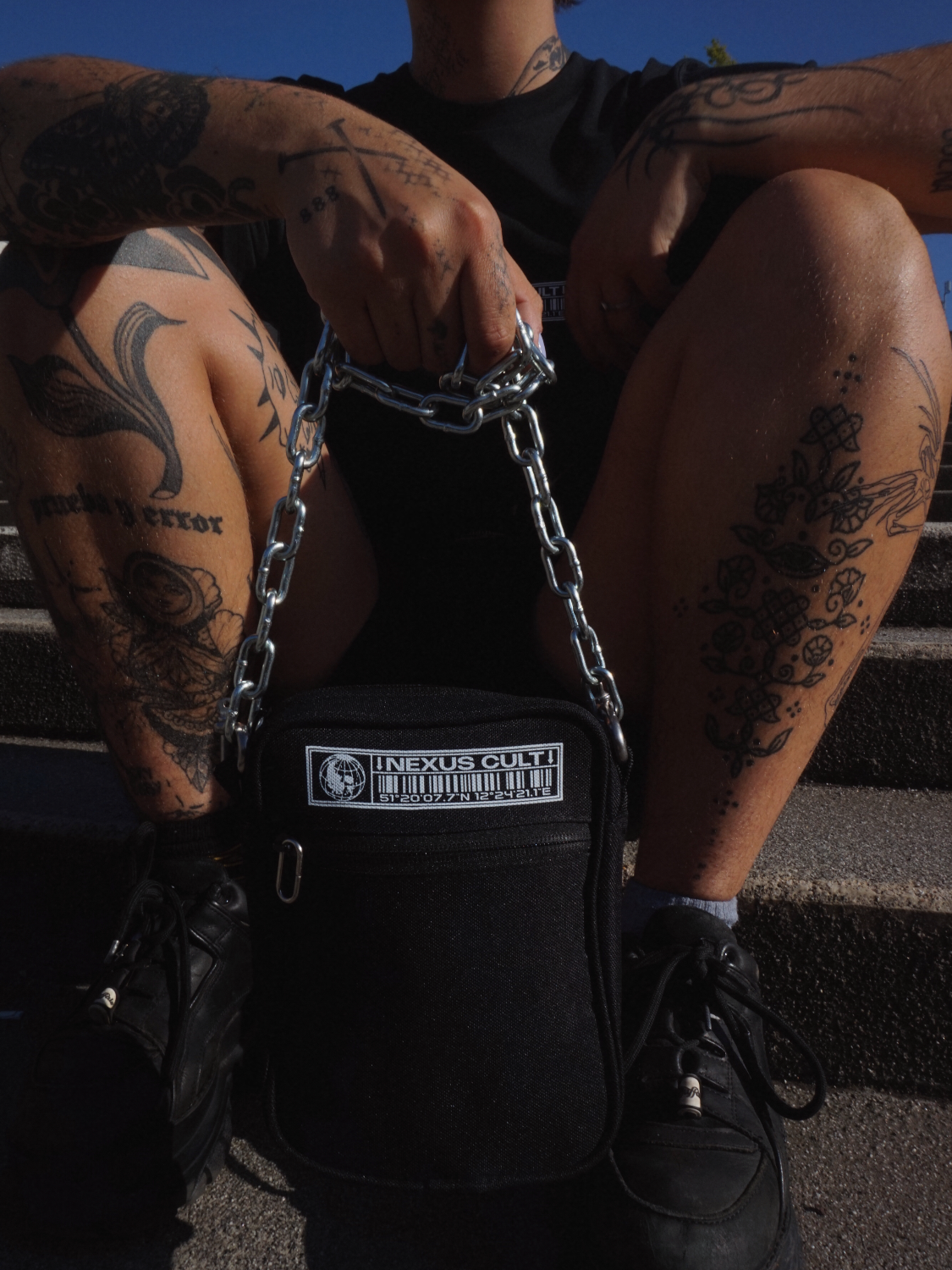 SCHWARZE TASCHE MIT KETTE UND AUFDRUCK.